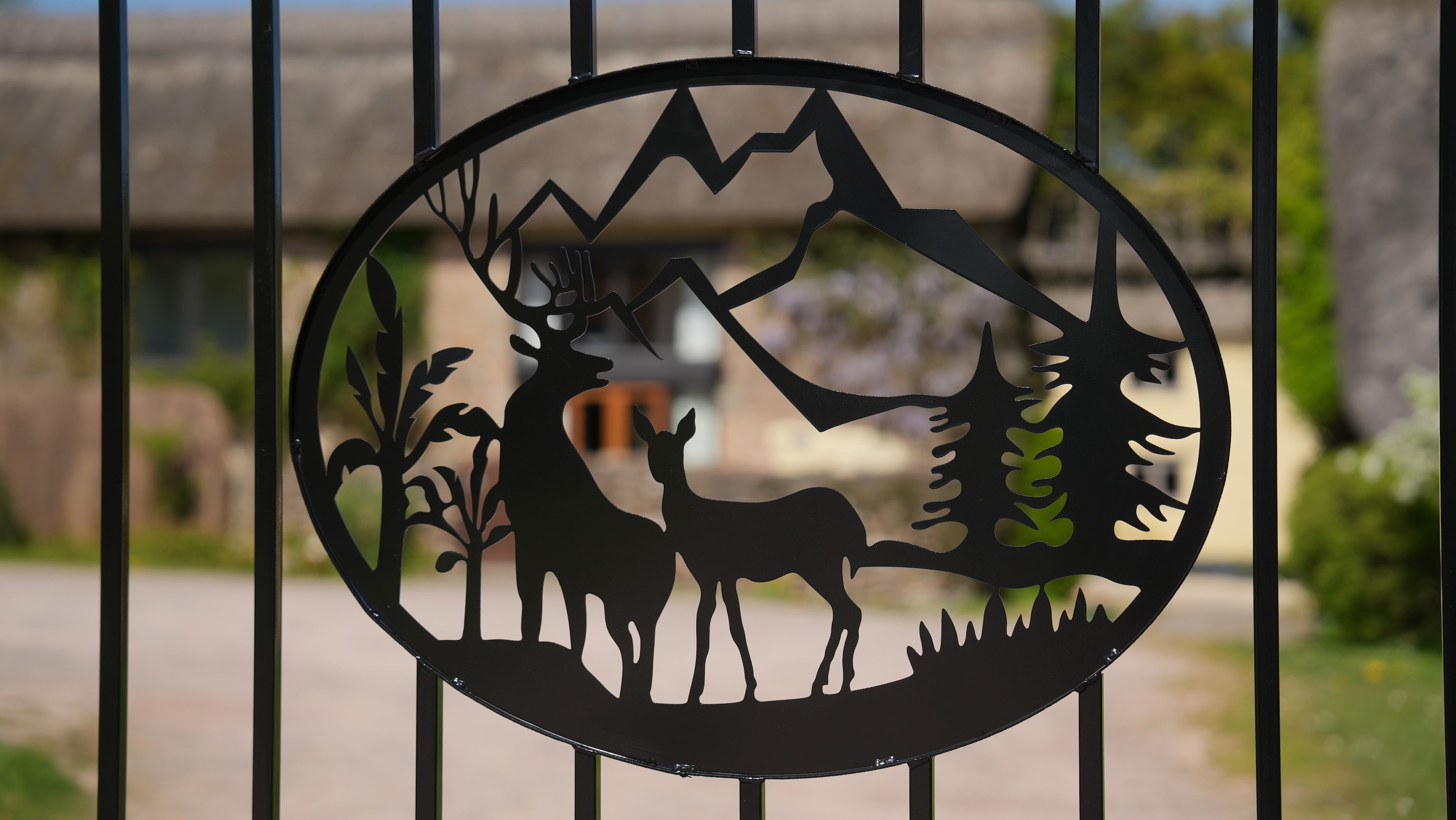 Decorative metal gate with deer and mountain design
